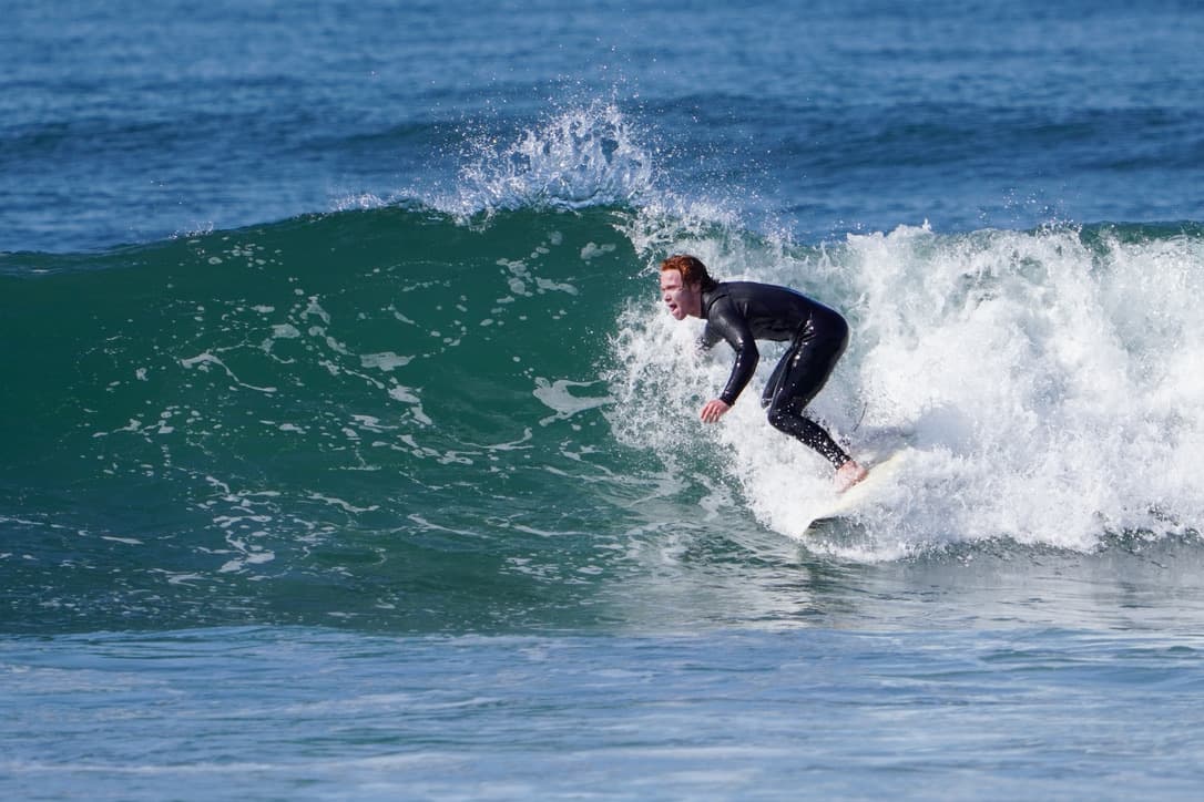 Ethan dropping into a wave while surfing